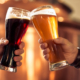 zwei menschen prosten sich mit einem bier zu