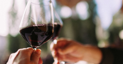 Couple cheering with glasses of red wine