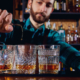 barman pours alcohol into a glass