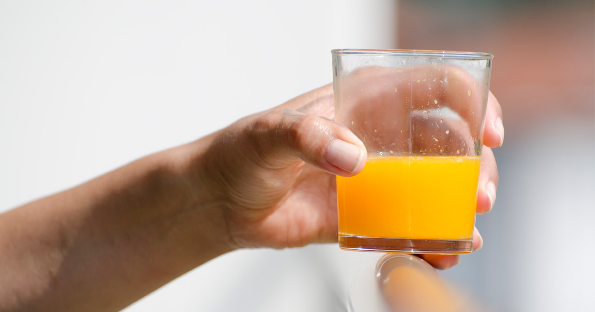 frau hand hält ein glas fruchtsaft